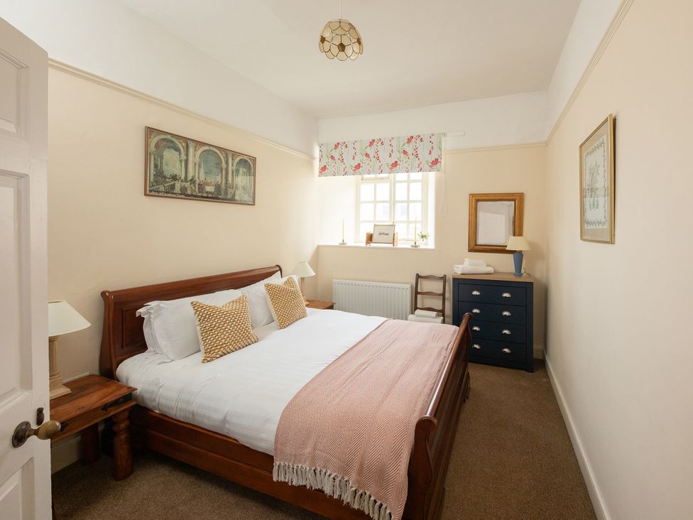 A bedroom featuring a bed, bedside table, and dresser at Bishop Lightfoot Cottage in Bishop Auckland