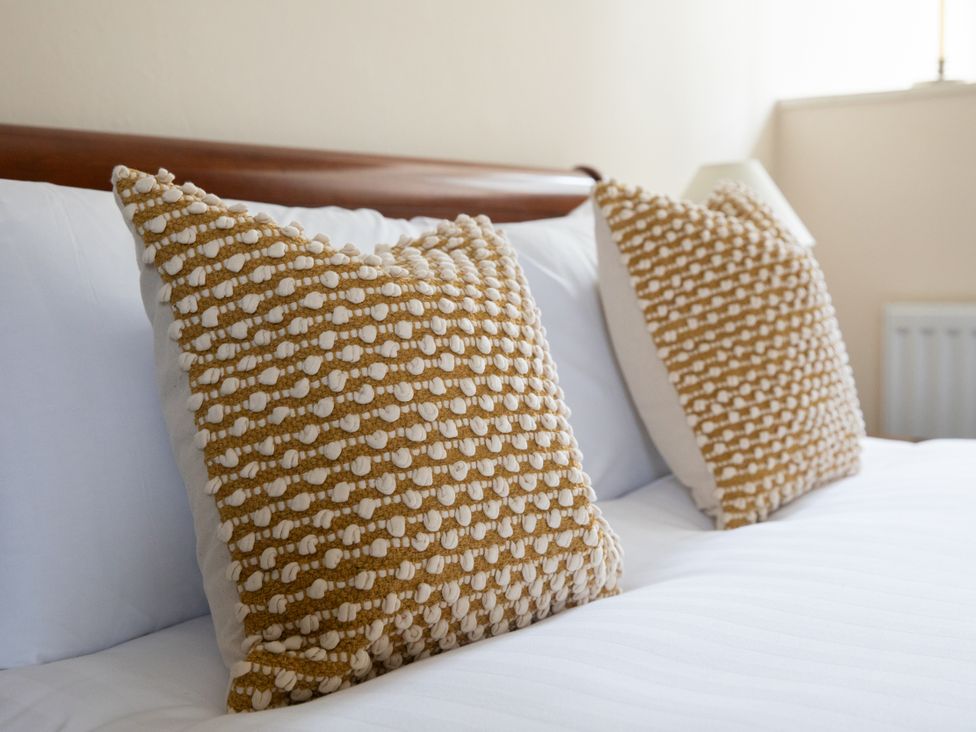 Two decorative pillows on a bed at Bishop Lightfoot Cottage in Bishop Auckland