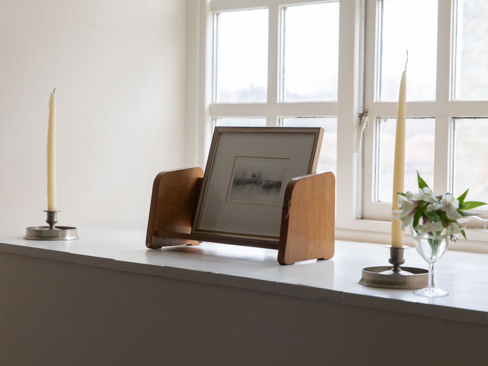 A living room with a wood frame holding a picture on a table at Bishop Lightfoot Cottage Bishop Auckland