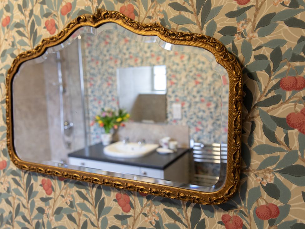 A bathroom with a mirror and sink at Bishop Lightfoot Cottage in Bishop Auckland