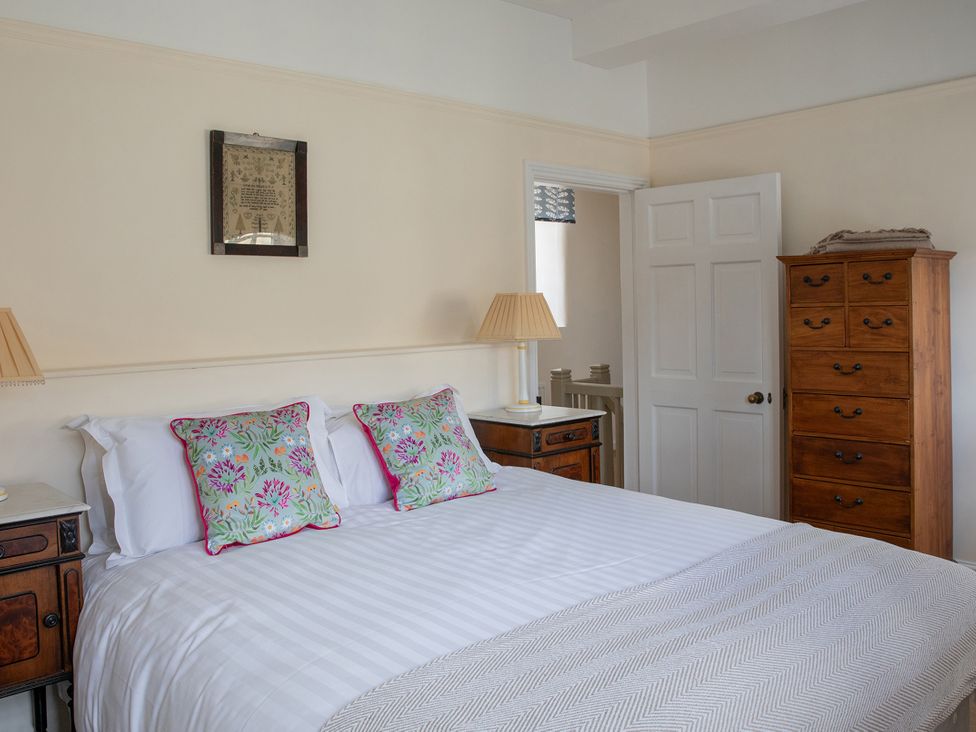 A bedroom with a bed and dresser at Bishop Lightfoot Cottage in Bishop Auckland