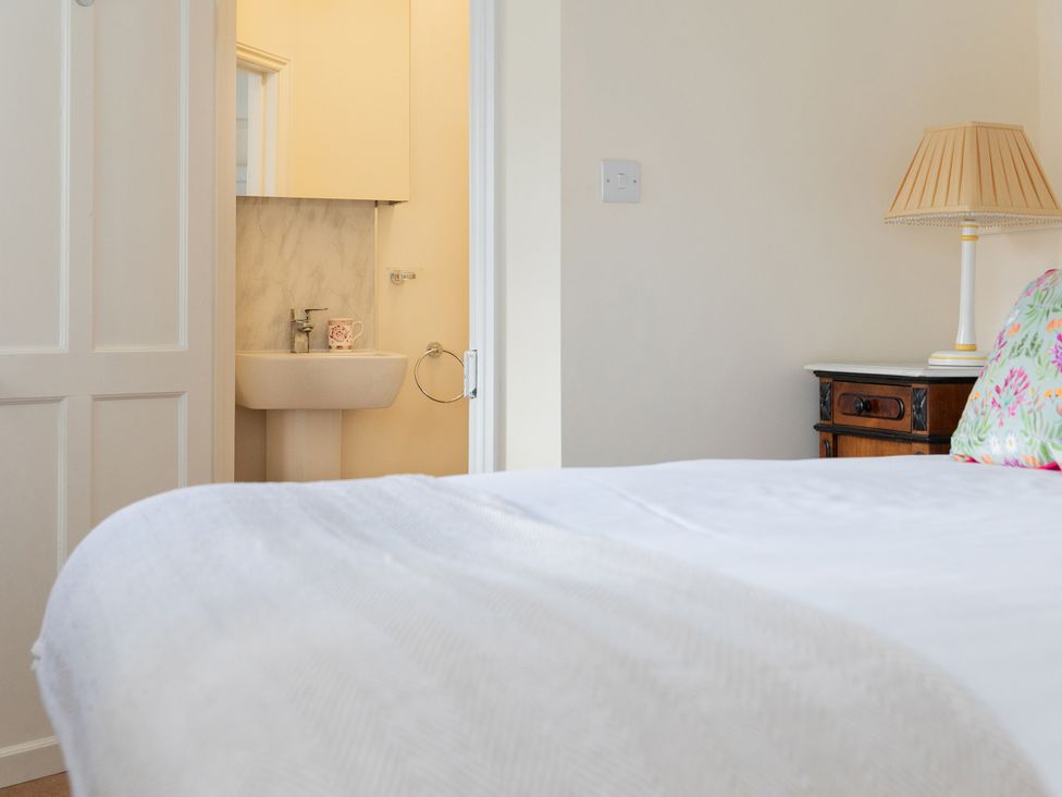A bedroom with a bed and a view of a sink at Bishop Lightfoot Cottage in Bishop Auckland