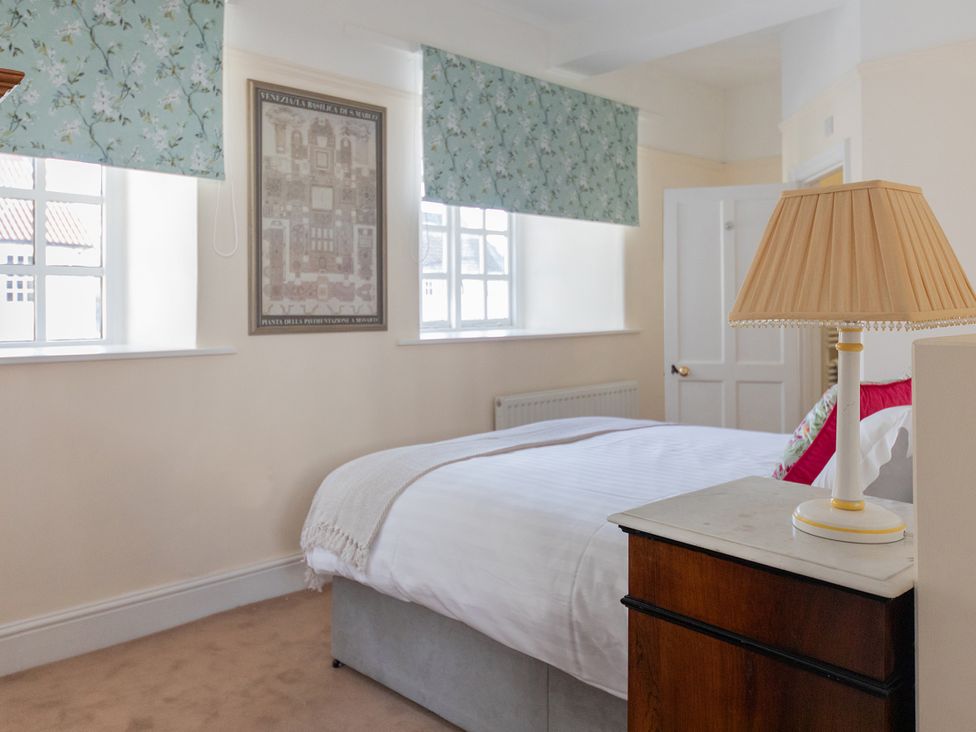 A bedroom with a bed and lamp at Bishop Lightfoot Cottage in Bishop Auckland