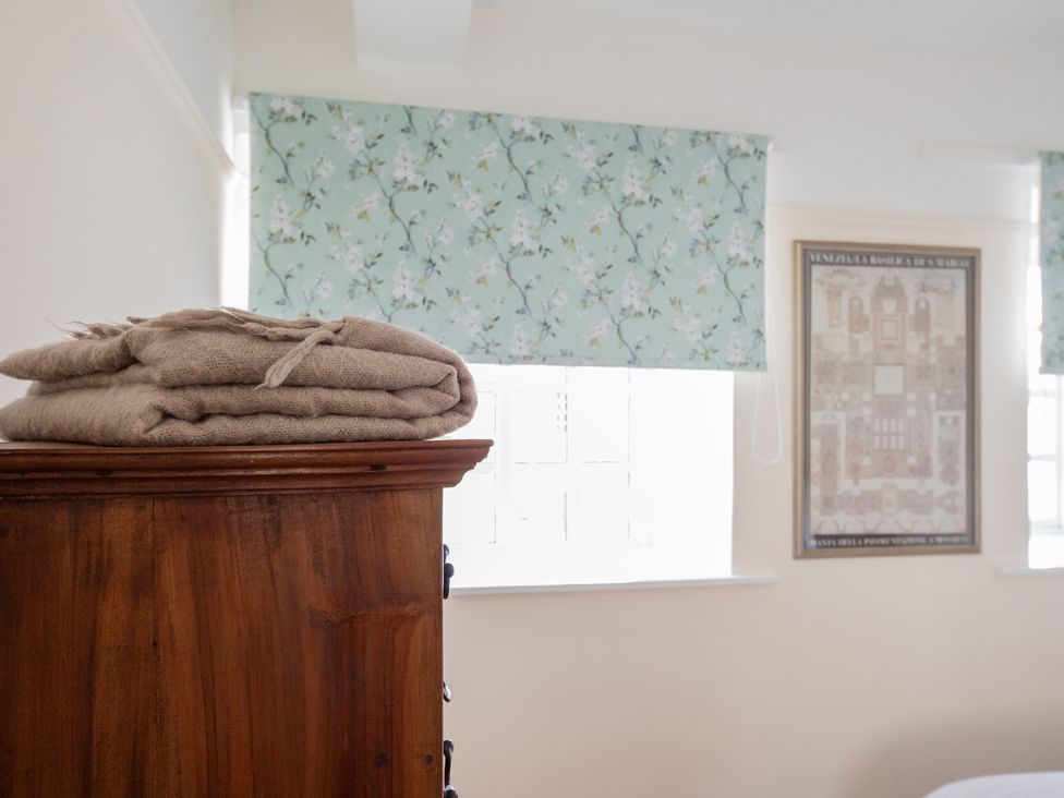 A bedroom with folded blankets on a wooden cabinet at Bishop Lightfoot Cottage in Bishop Auckland