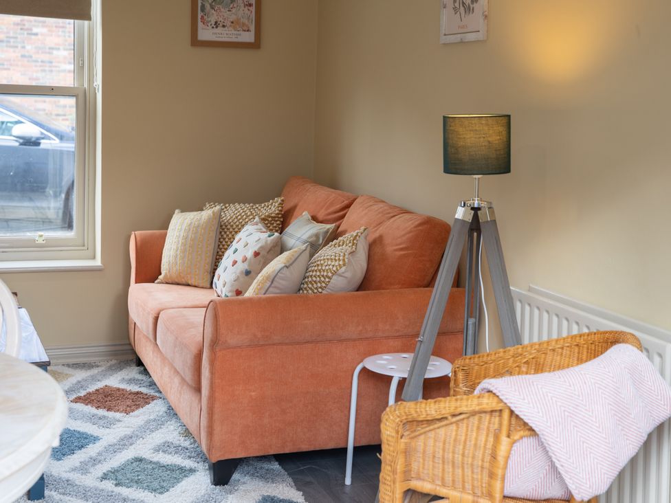 A living room with a sofa and lamp at Sheriff's Tower Cottage - East in Bishop Auckland