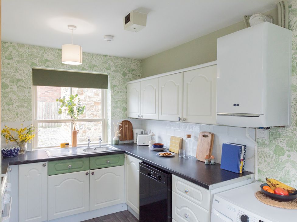 A kitchen with a sink and cabinets at Sheriff's Tower Cottage - East in Bishop Auckland