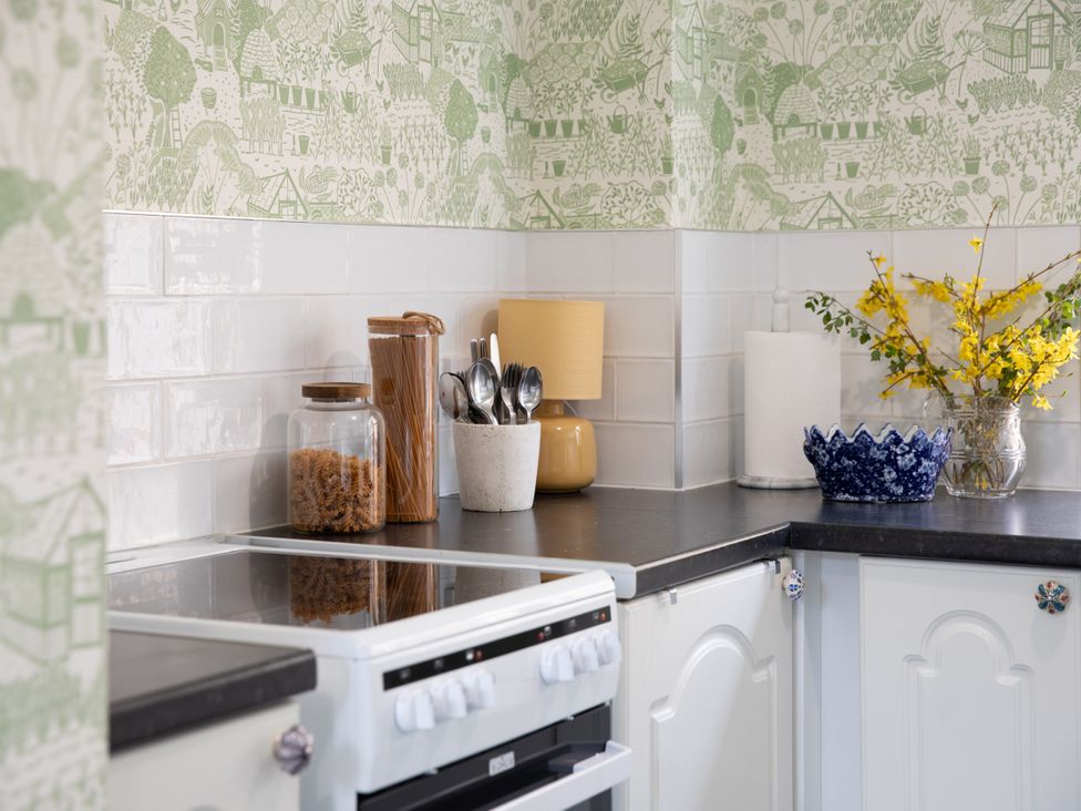 A kitchen with a stove and jars on the countertop at Sheriff's Tower Cottage - East Bishop Auckland