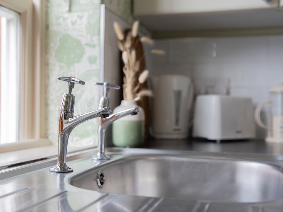 A kitchen with a sink and faucets at Sheriff's Tower Cottage - East in Bishop Auckland