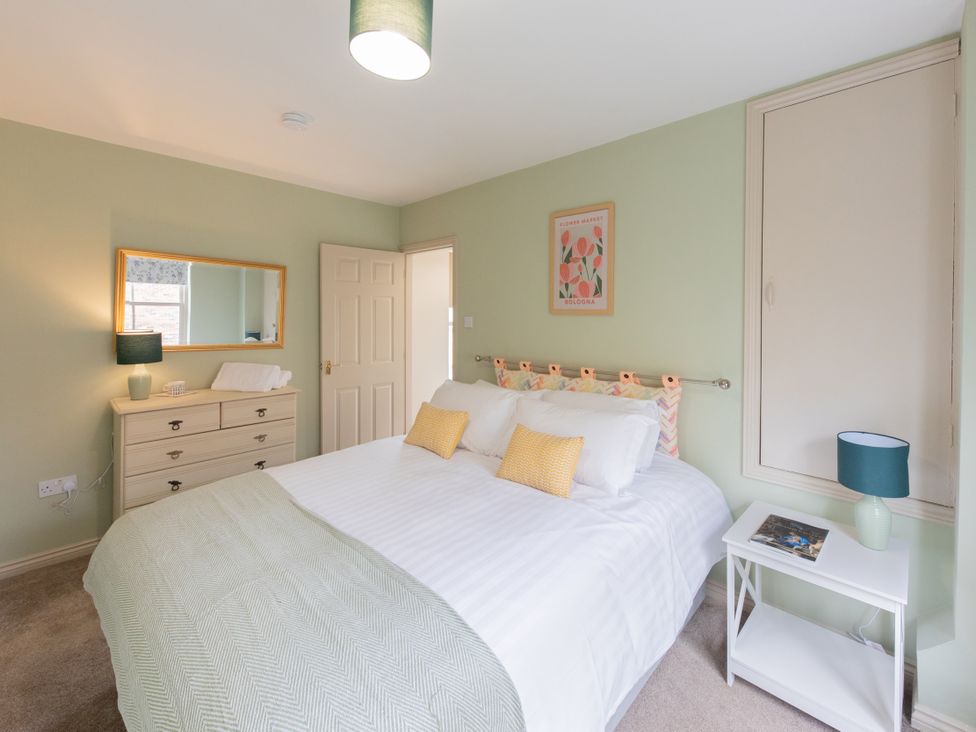 A bedroom with a bed and bedside table at Sheriff's Tower Cottage - East, Bishop Auckland