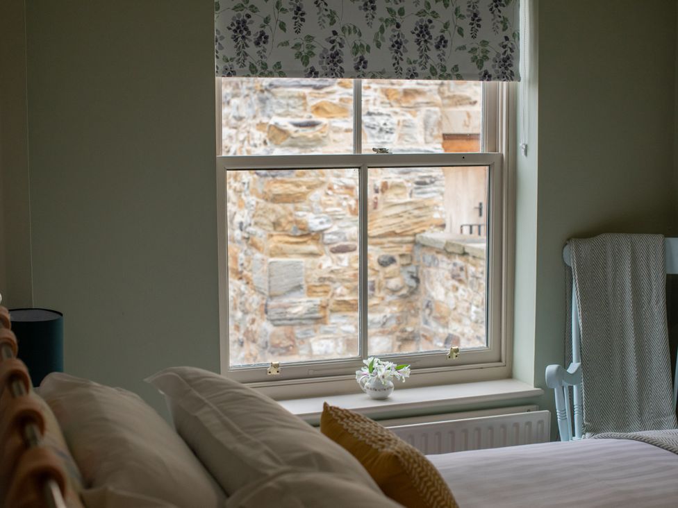 A bedroom with a window and bed at Sheriff's Tower Cottage - East in Bishop Auckland