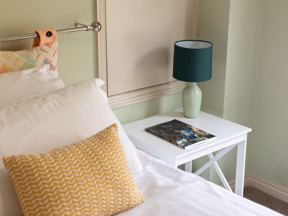 A bedroom with a bed and nightstand at Sheriff's Tower Cottage - East in Bishop Auckland