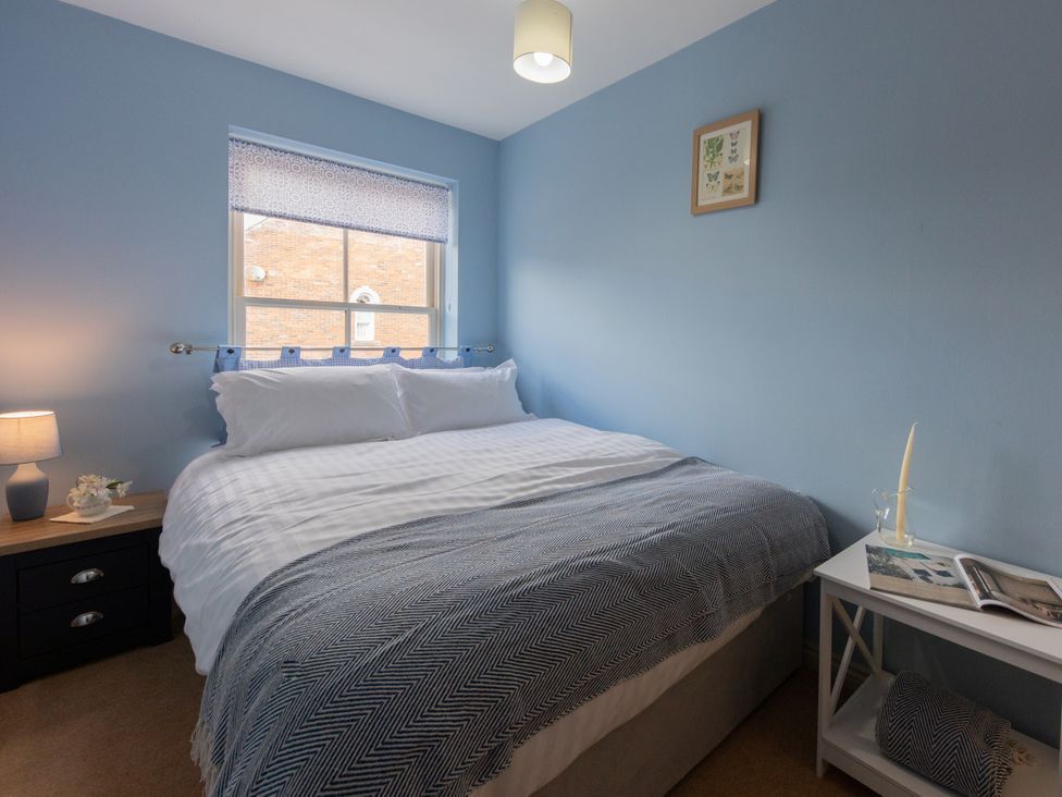 A bedroom with a bed and nightstand at Sheriff's Tower Cottage - East in Bishop Auckland