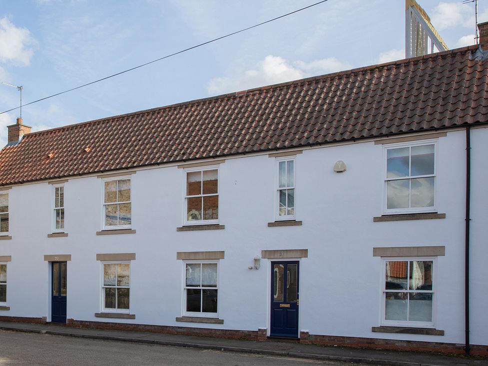 A house with windows and a blue door at Sheriff's Tower Cottage - East in Bishop Auckland