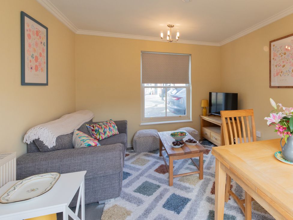 A living room with a sofa, coffee table, and television at Sheriff's Tower Cottage - West, Bishop Auckland