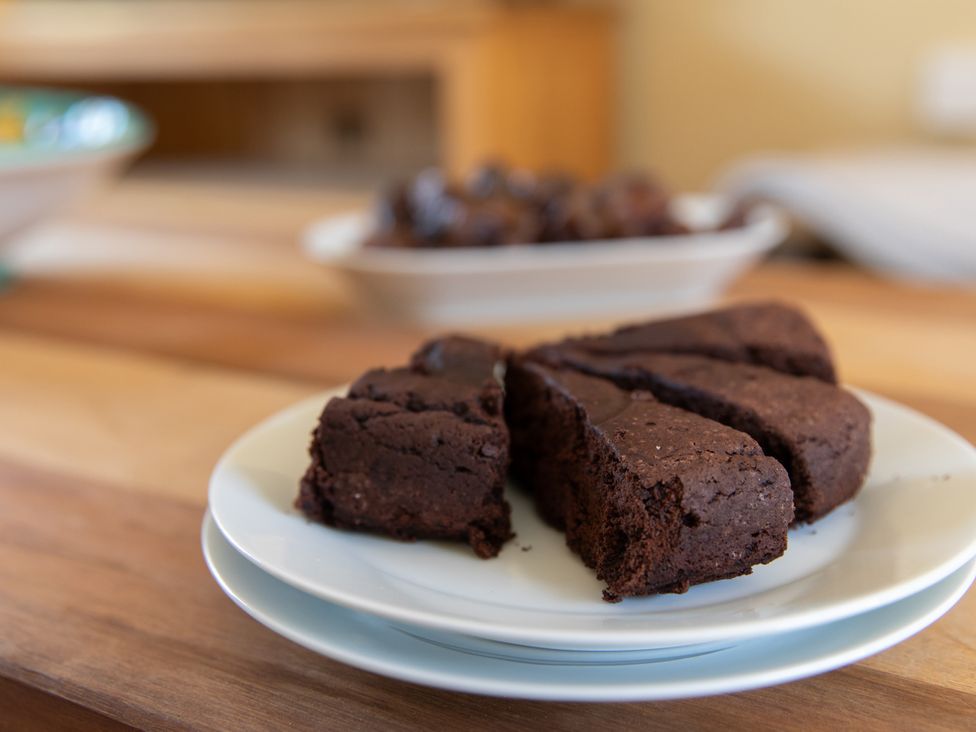 A plate with sliced cake on a table at Sheriff's Tower Cottage - West Bishop Auckland