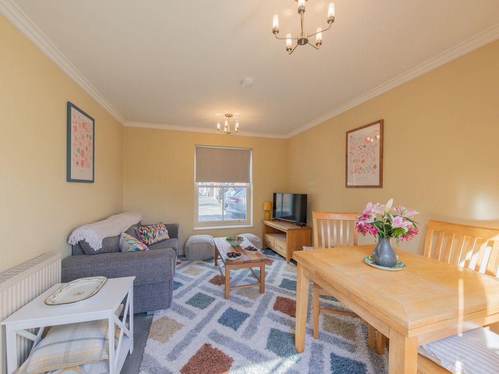 A living room with a dining table and television at Sheriff's Tower Cottage - West Bishop Auckland