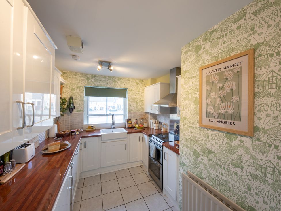 A kitchen with a sink, oven, and wall art at Sheriff's Tower Cottage - West in Bishop Auckland
