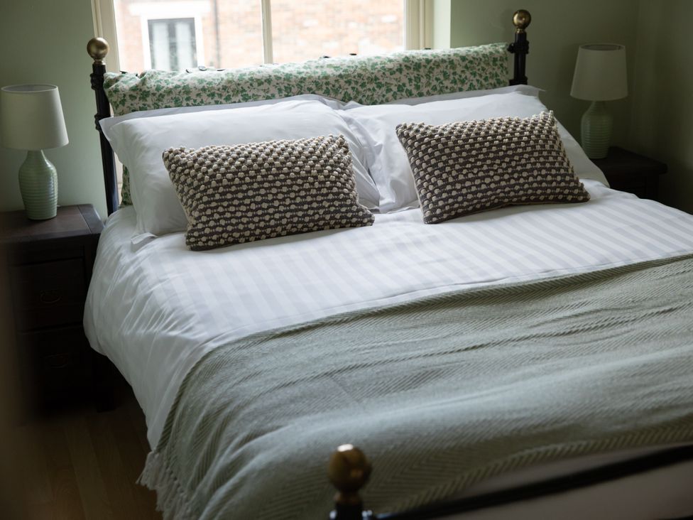 A bedroom with a bed and bedside table at Sheriff's Tower Cottage - West Bishop Auckland
