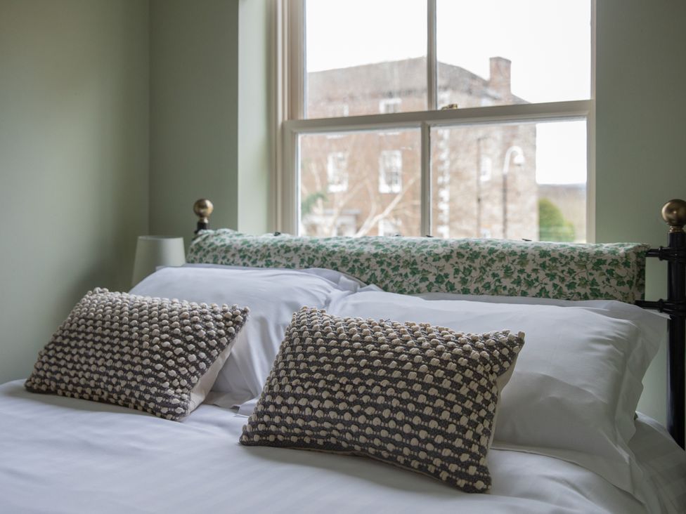 A bedroom with a bed and pillows at Sheriff's Tower Cottage - West in Bishop Auckland