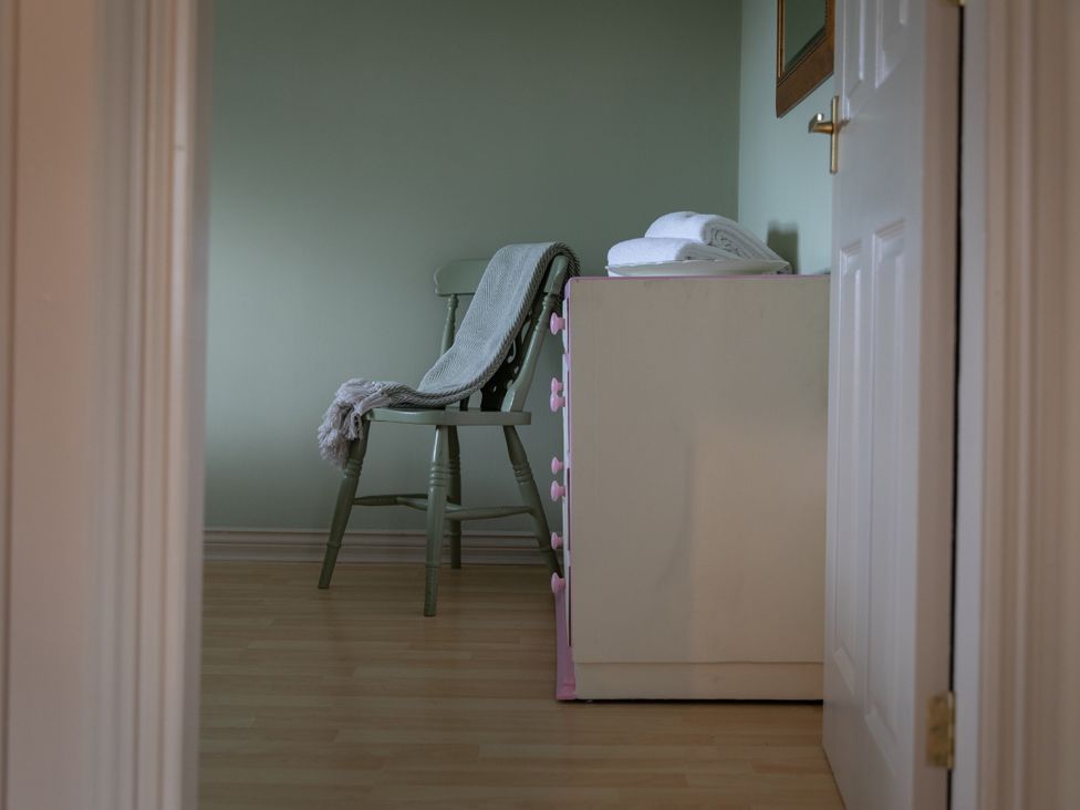 A bedroom with a chair and towels at Sheriff's Tower Cottage - West Bishop Auckland