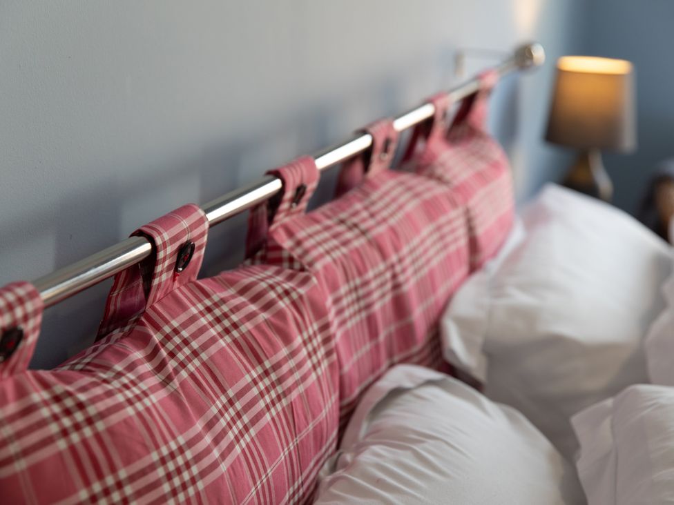 A bed with headboard and pillows at Sheriff's Tower Cottage - West in Bishop Auckland