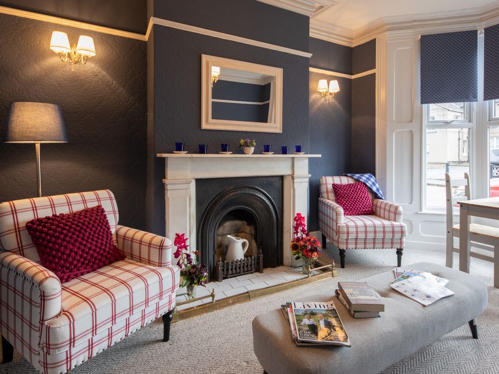 A living room with armchairs and a fireplace at No 2 Townhouse in Bishop Auckland