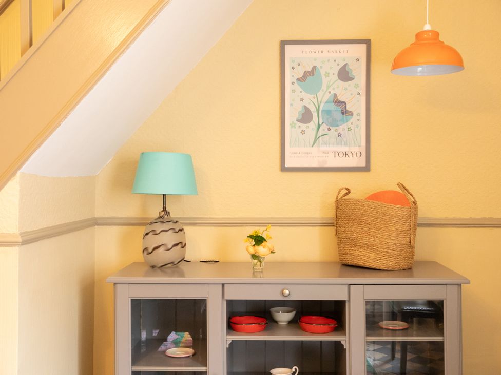 A dining room with a cabinet and flowers on a table at No 2 Townhouse Bishop Auckland