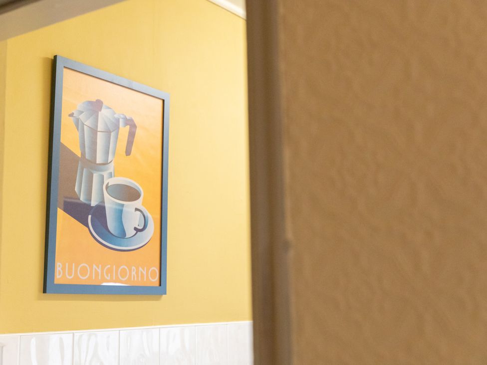 A coffee maker and cup framed on a yellow wall at No 2 Townhouse Bishop Auckland