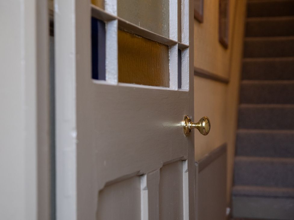 A door and staircase in the hallway at No 2 Townhouse in Bishop Auckland