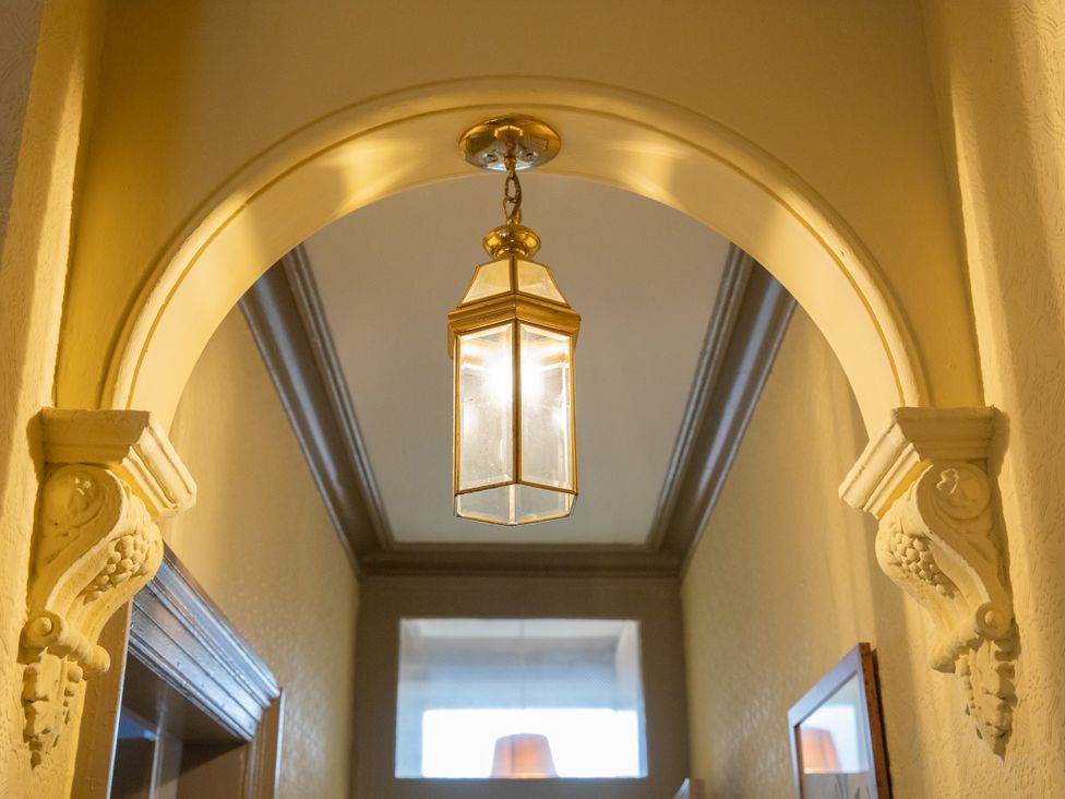 A hallway with a lantern hanging from an archway at No 2 Townhouse in Bishop Auckland