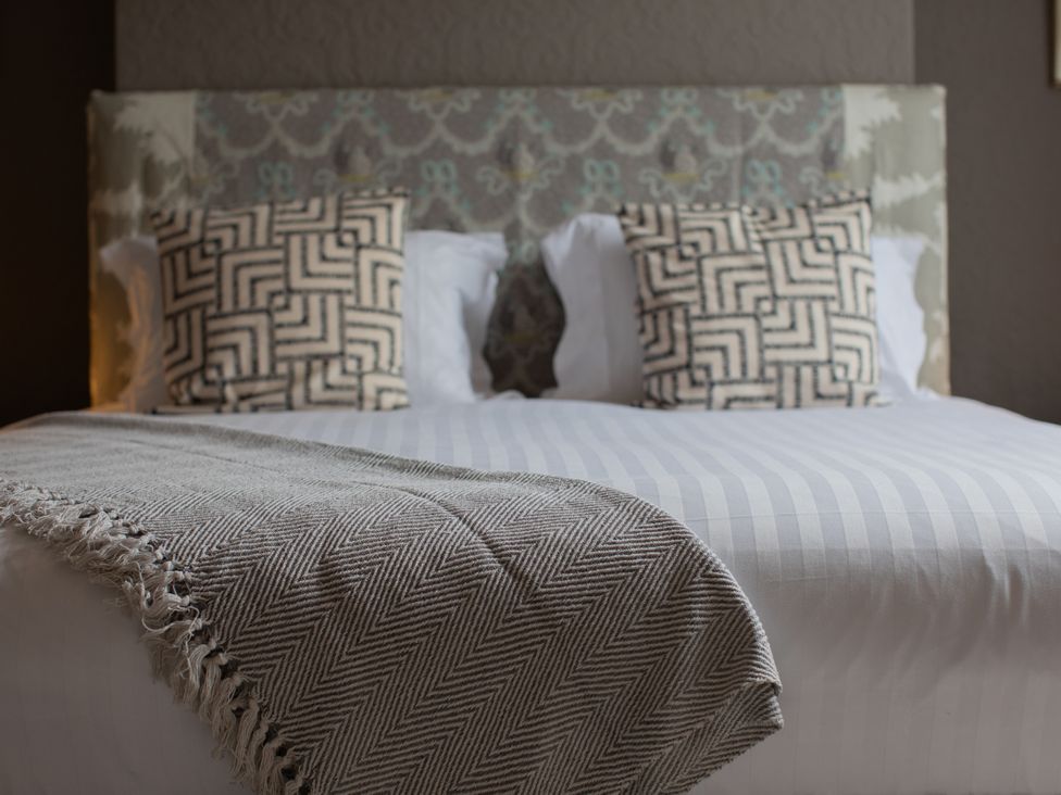 A bed with pillows and a blanket at No 2 Townhouse in Bishop Auckland