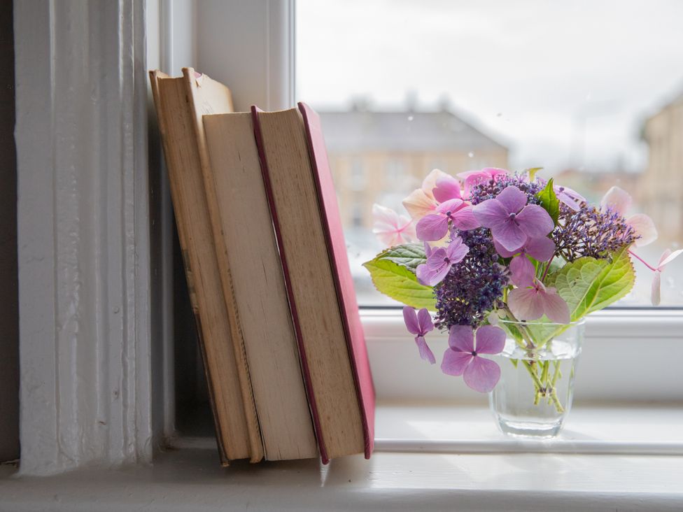 A window with books and a vase of flowers at No 2 Townhouse in Bishop Auckland
