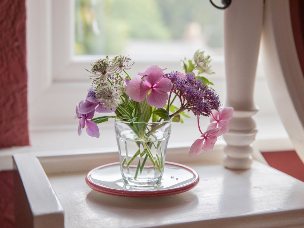 A glass with flowers on a table at No 2 Townhouse in Bishop Auckland