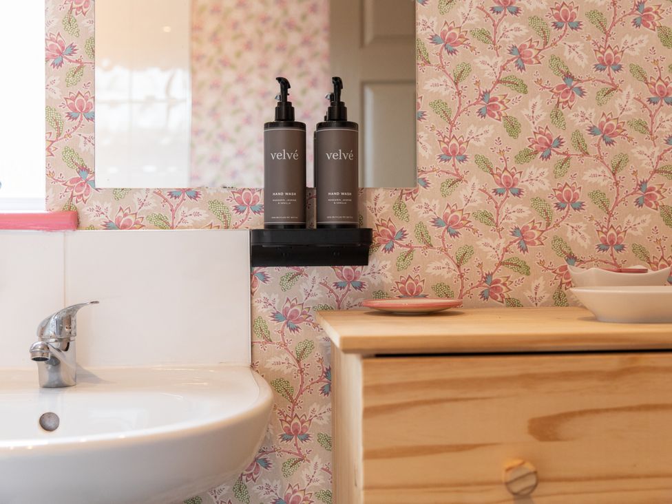 A bathroom with a sink and hand wash bottles at No 2 Townhouse in Bishop Auckland