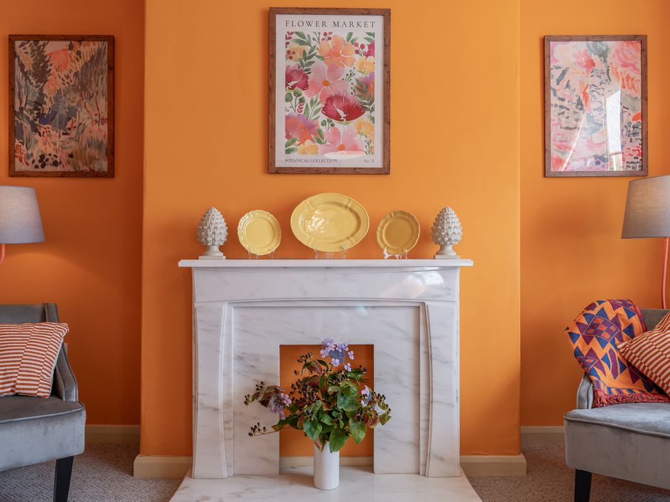 A living room with a fireplace and artwork at No 4 Townhouse in Bishop Auckland