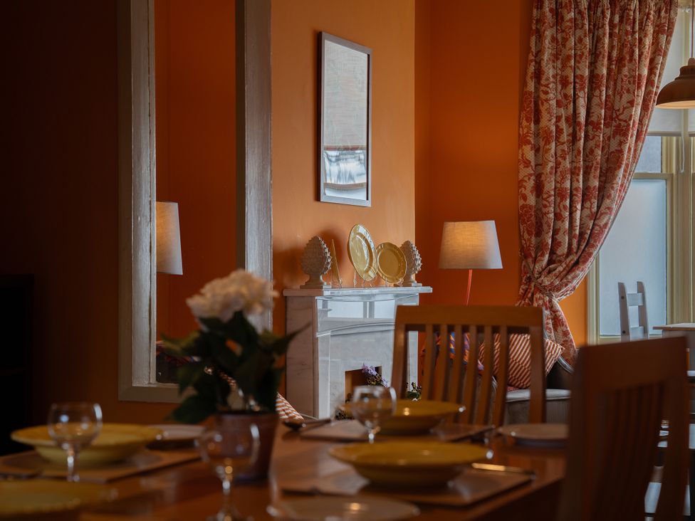 A dining room with a table set and a fireplace at No 4 Townhouse in Bishop Auckland