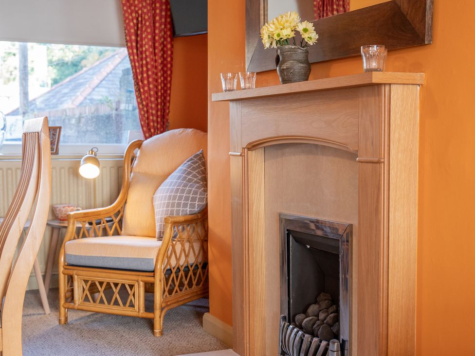 A living room with an armchair and a fireplace at No 4 Townhouse in Bishop Auckland