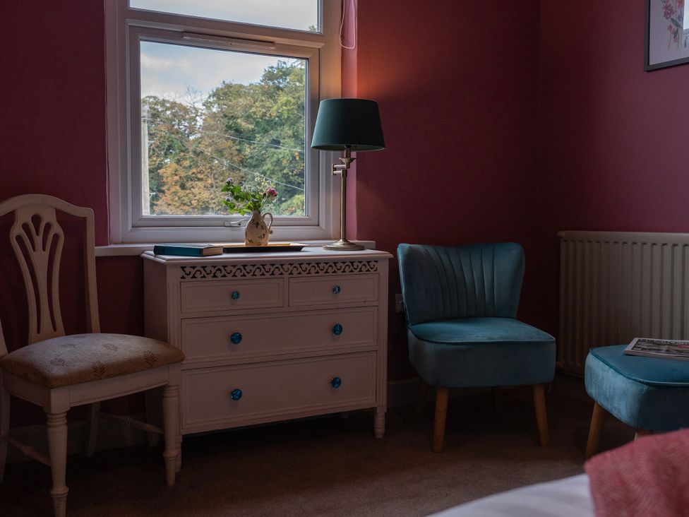 A bedroom with a window, two chairs and a lamp at No 4 Townhouse in Bishop Auckland