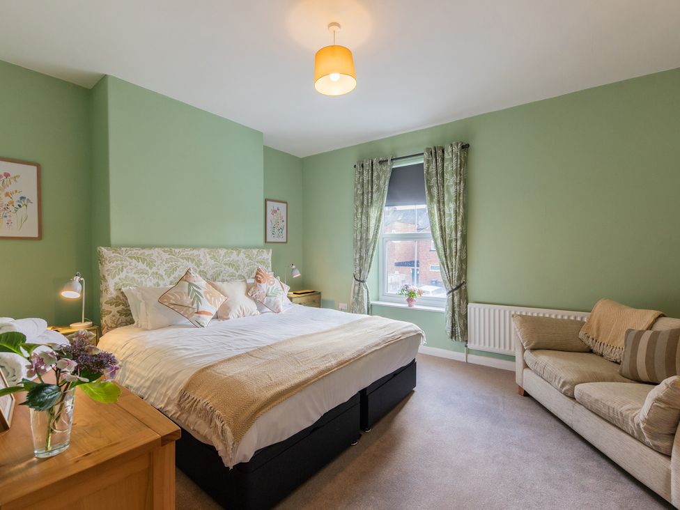 A bedroom with a bed and sofa at No 4 Townhouse in Bishop Auckland