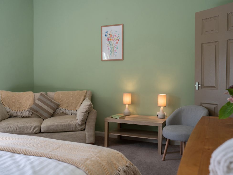 A living room with a sofa and lamps at No 4 Townhouse in Bishop Auckland