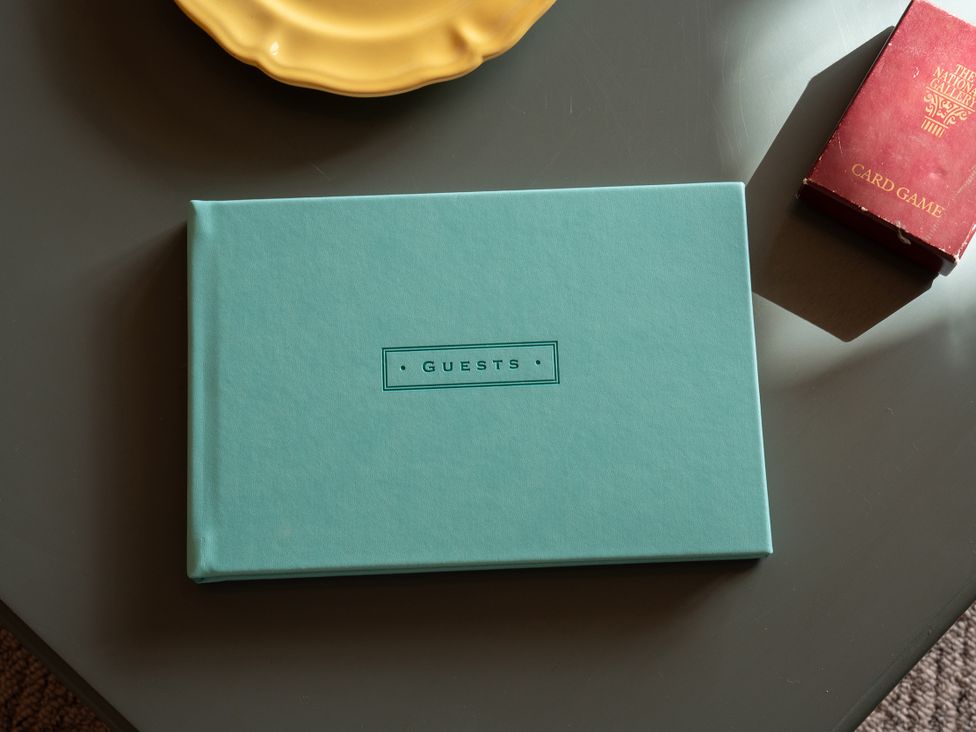 A guest book and card game on a table at No 4 Townhouse in Bishop Auckland