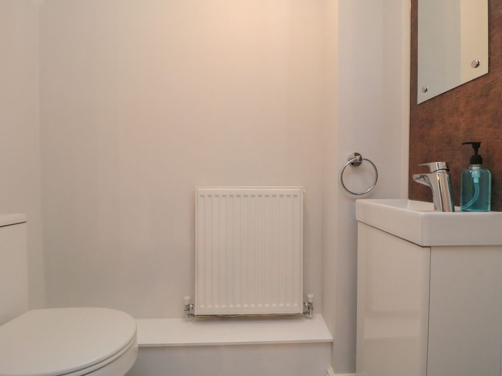 A bathroom with a toilet, sink, and mirror at 3 Railway Terrace Bridlington