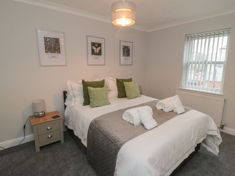 A bedroom with a bed and wall art at 3 Railway Terrace Bridlington