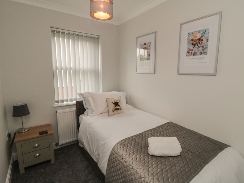 A bedroom with a single bed and wall art at 3 Railway Terrace Bridlington