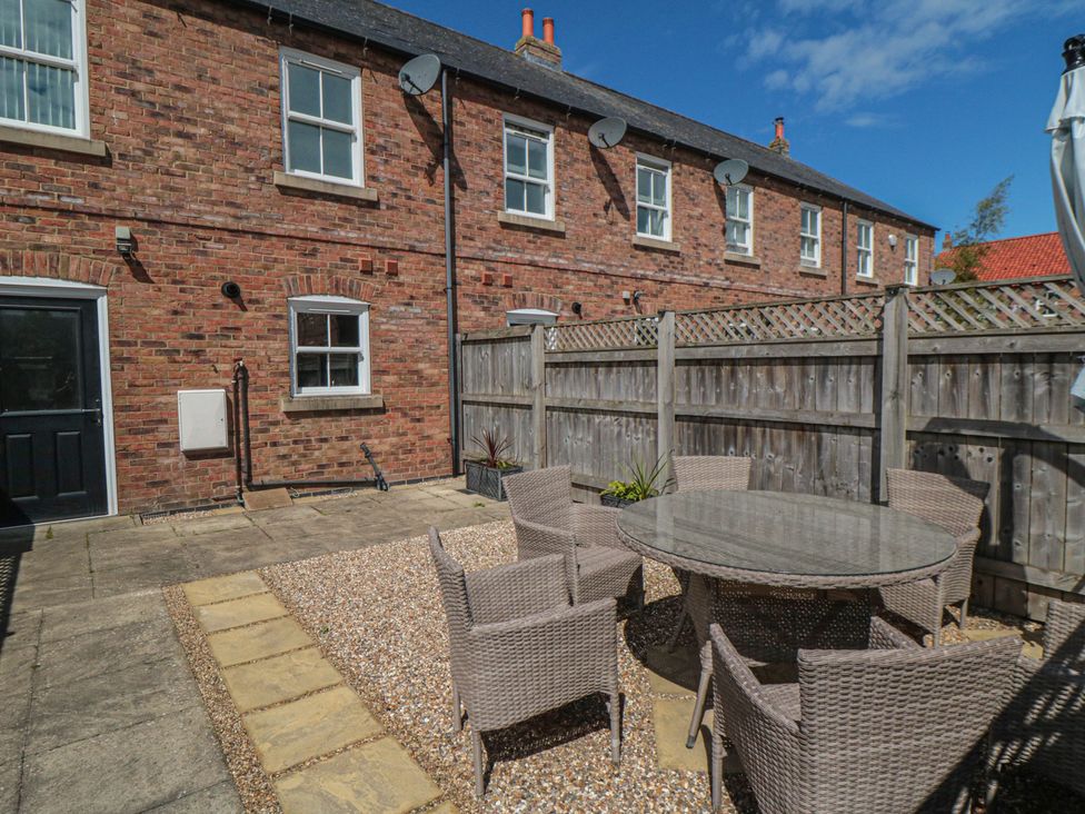 An outdoor area with a table and chairs in a courtyard at 3 Railway Terrace Bridlington