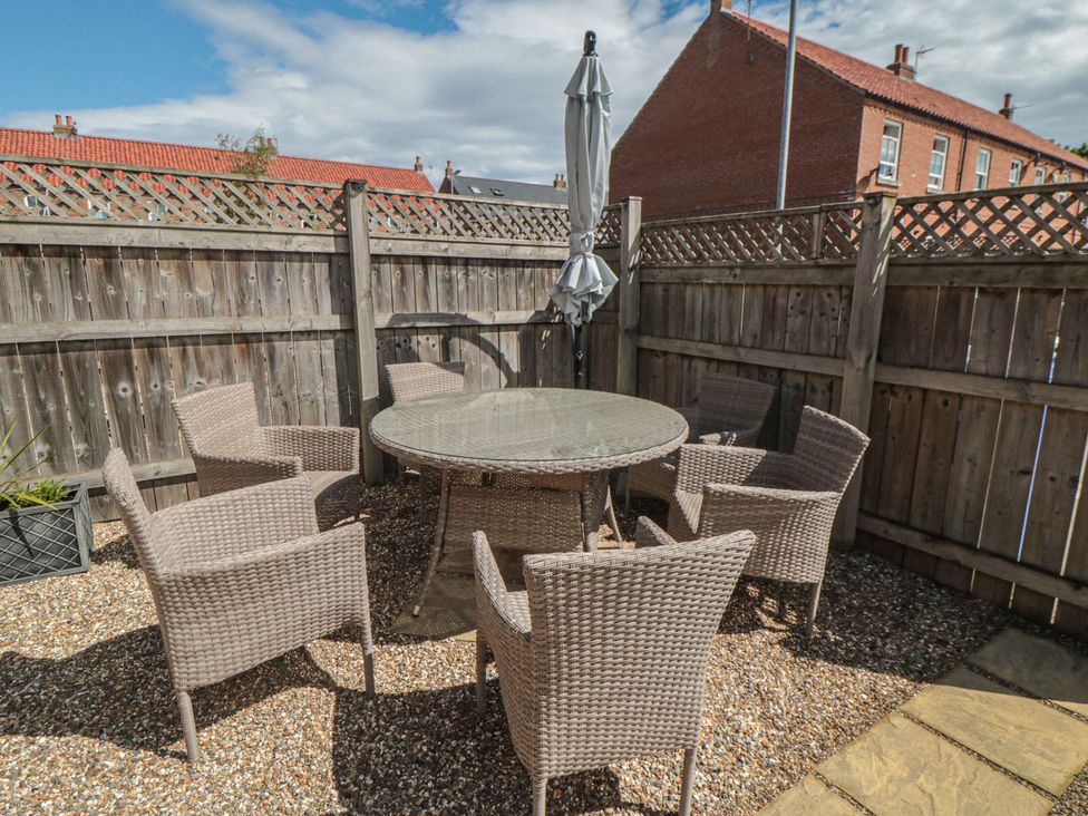 A garden with a table and chairs under an umbrella at 3 Railway Terrace Bridlington