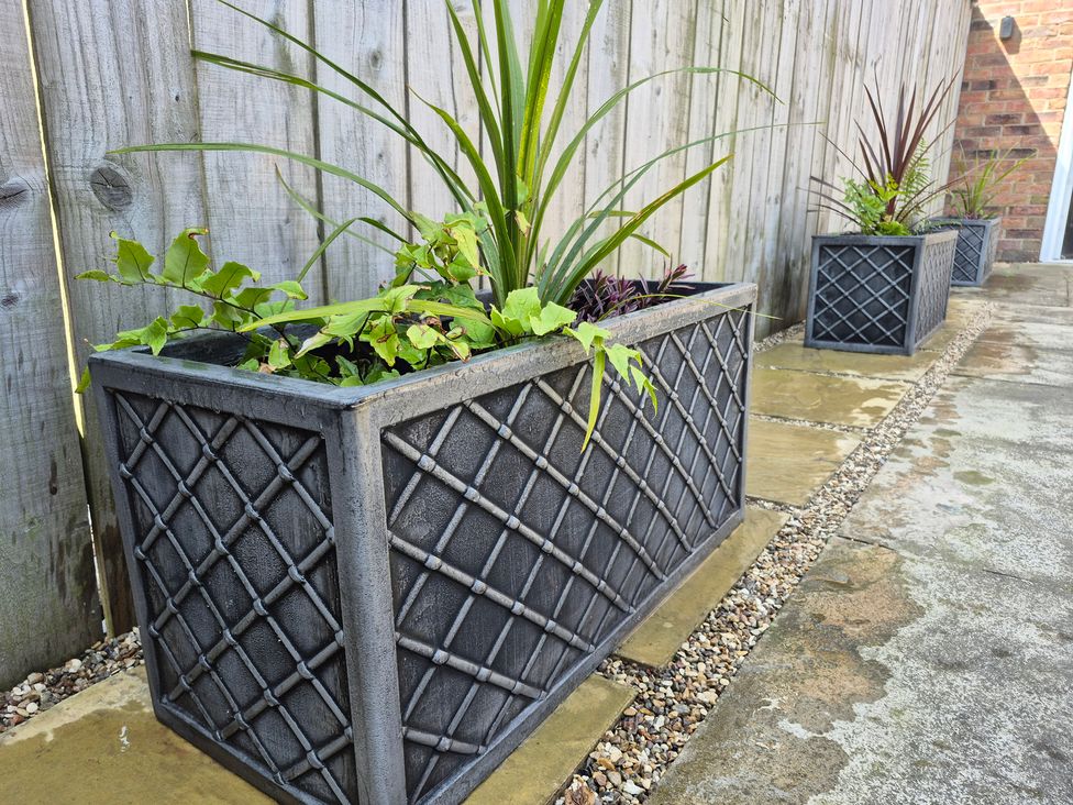 A row of planters with plants alongside a gravel path at 3 Railway Terrace in Bridlington