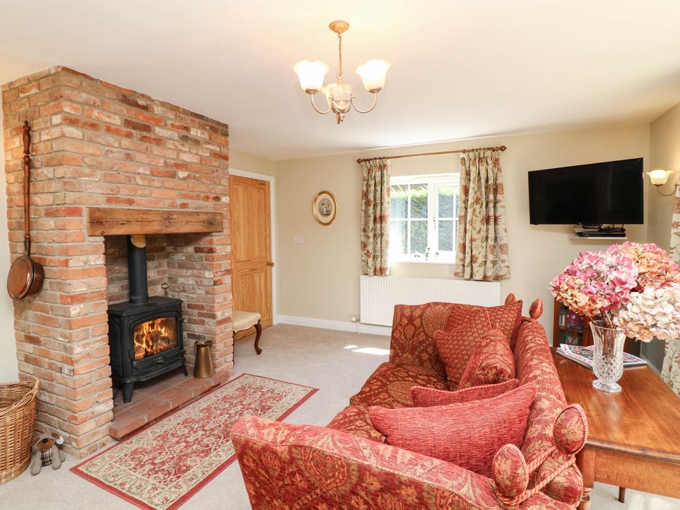 A living room with a brick fireplace and a sofa at Wisteria House in Lincoln