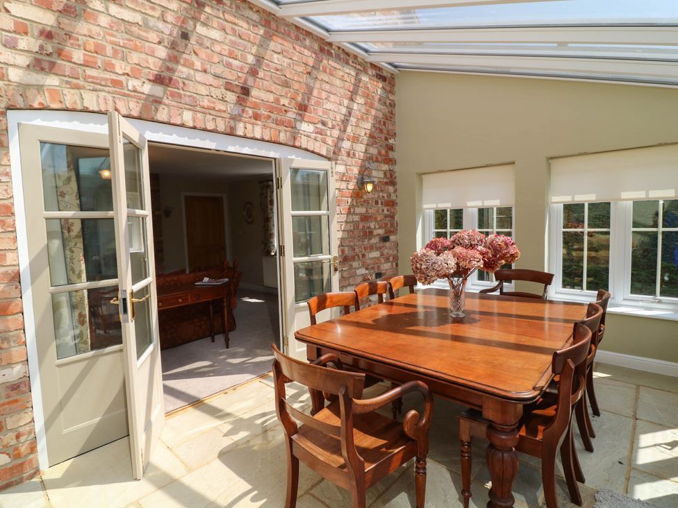 A dining room with a wooden table and chairs at Wisteria House in Lincoln