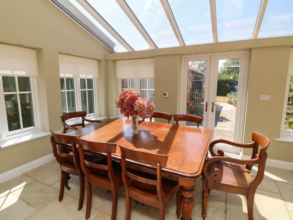 A dining room with a wooden table and chairs at Wisteria House in Lincoln